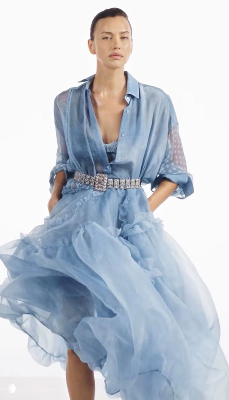 Движущийся кадр модели в лёгком голубом платье с пышной юбкой — романтичный студийный образ рекламной кампании бренда.