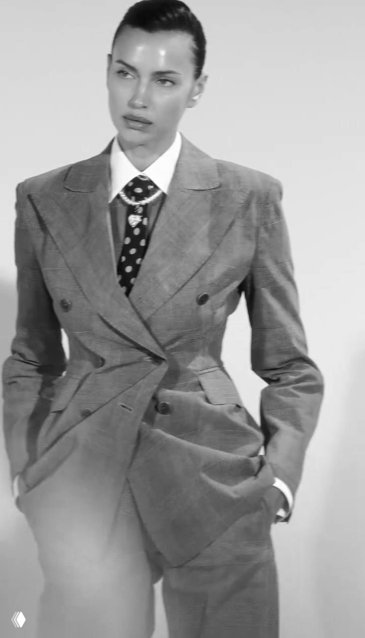 Черно‑белая фотография модели в двубортном костюме и галстуке — деловой и строго стильный образ из рекламной съёмки.