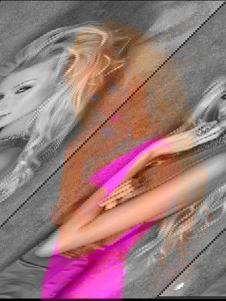 Портретная фотография женщины в насыщенном розовом платье на фоне нейтральной серой текстуры; студийная съёмка в гламурном ключе.