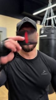 Фрагмент видео: мужчина в чёрной футболке и кепке приближает предмет к камере; типичный ракурс для сторис и коротких роликов в соцсетях.