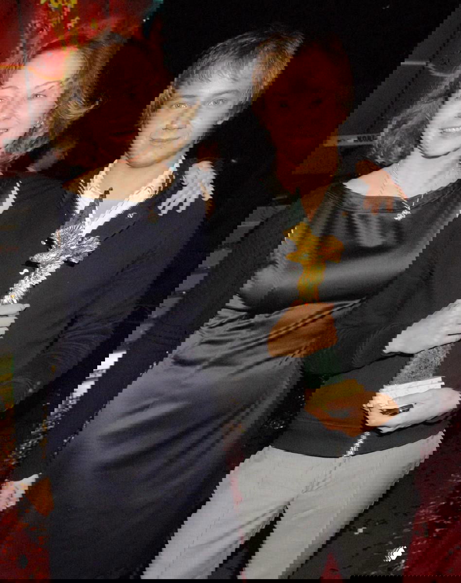 Архивное фото: Евгения Добровольская рядом с молодым мужчиной, который держит статуэтку награды, торжественный фон сцены и праздничная обстановка на мероприятии.