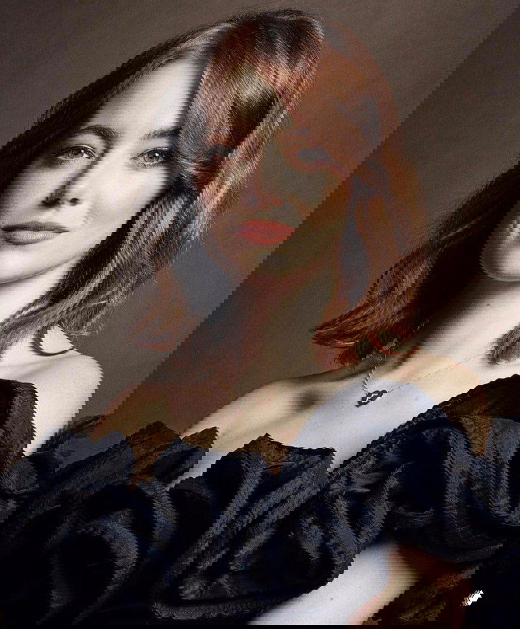 Студийный портрет в тёплой цветовой гамме: актриса в наряде с открытыми плечами и мягким светом, классический портретный снимок.