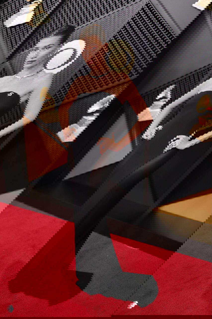 Хейли Бибер в облегающем чёрном платье без бретелей с высоким боковым разрезом на красной дорожке «Грэмми — 2026».