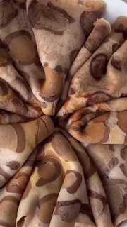 Разложенные в круг блины с ярким леопардовым узором коричневых и бежевых пятен на светлой поверхности; виден рисунок на каждом блинчике.