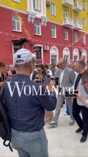Толпа и Федор Добронравов на открытии Улицы ангела в Ярославле; кадр с разноцветными фасадами и гостями, водяной знак Woman.ru