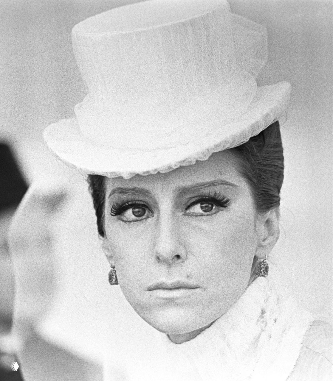 Крупный чёрно‑белый портрет Майи Плисецкой в цилиндре и театральном макияже: характерный образ артистки в одной из ролей, ретро-стилизация съёмки