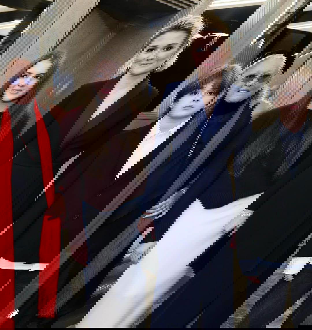 Групповой портрет в фойе: женщина в тёмном платье, рядом молодая девушка и ребёнок — семейный кадр с гостями торжества.