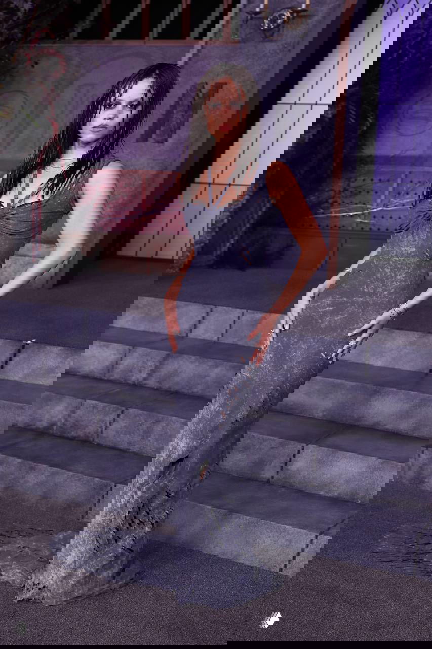 Платье в потёртом сером оттенке с эффектом «мокрой» текстуры, готический стилизованный образ для премьеры, ступени и сценический фон на заднем плане