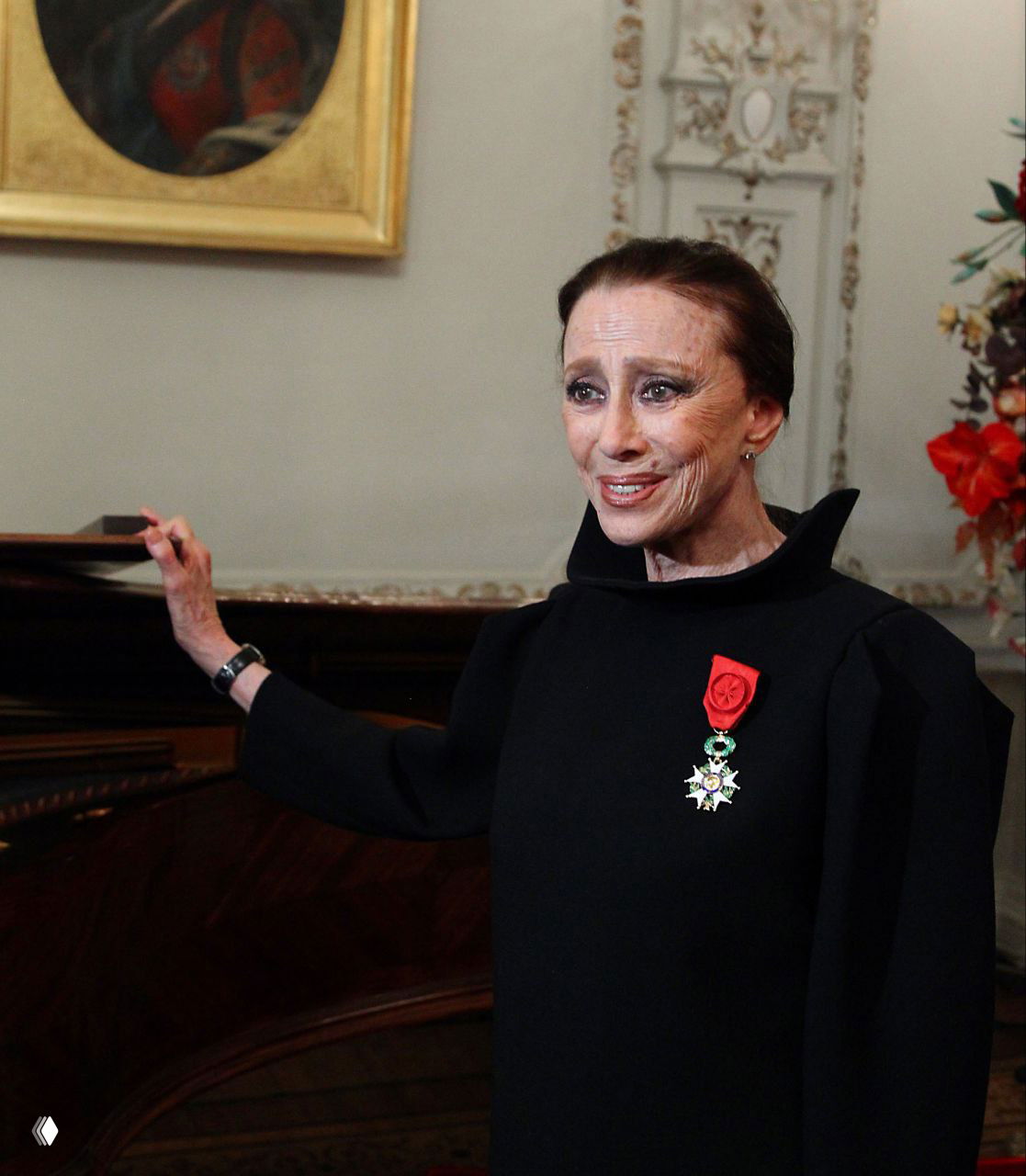 Майя Плисецкая в чёрном платье с орденом на груди в интерьере — официальный кадр, демонстрирующий признание заслуг и награды выдающейся артистки