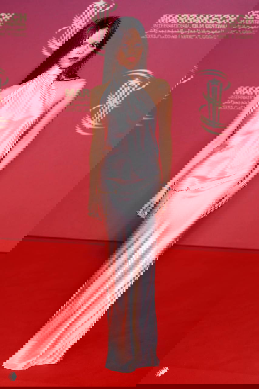 Шёлковое светлое платье на красной дорожке: скользящий сатиновый силуэт, тонкие цепочки в качестве аксессуаров, классический гламурный стиль