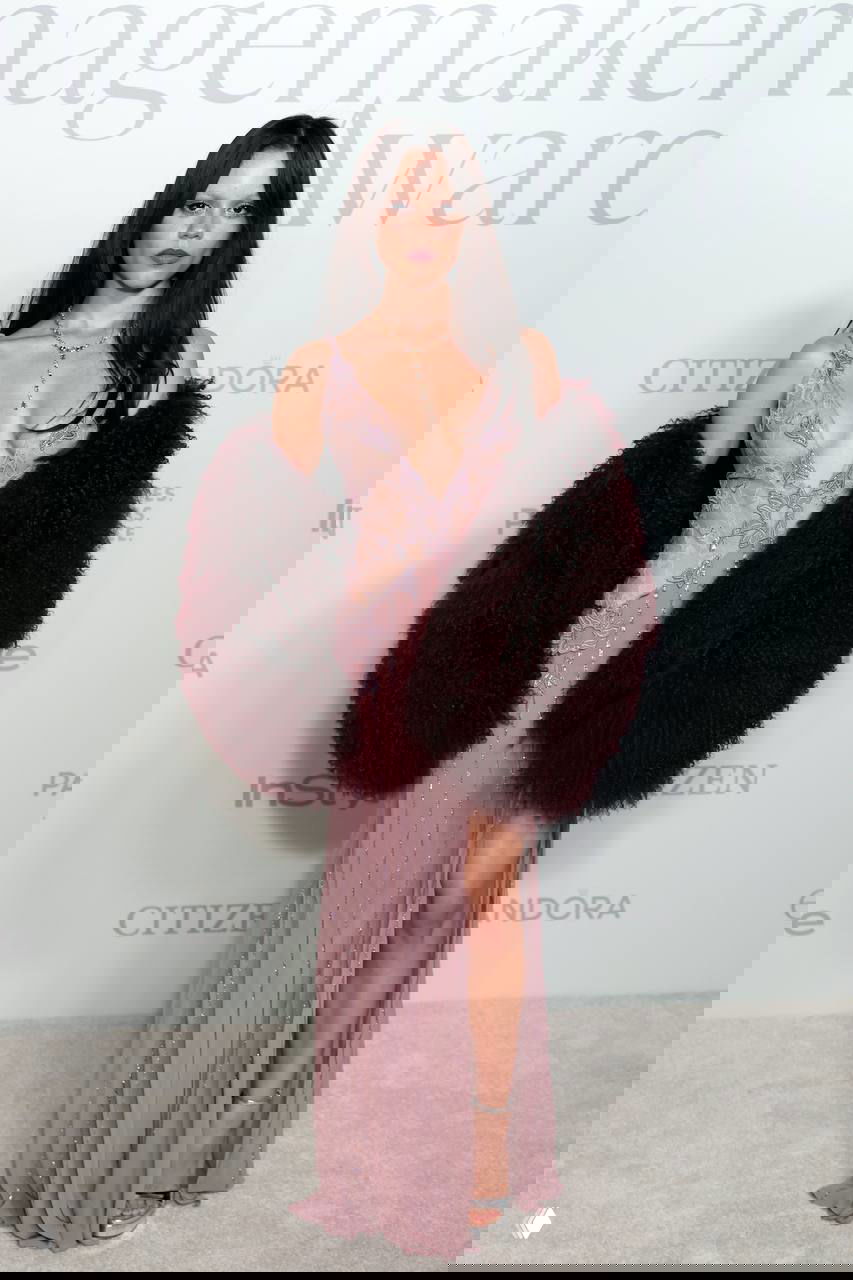 Платье светлого тона в сочетании с объёмной тёмной меховой накидкой, образ для церемонии с подчеркнутым декольте и длинным силуэтом, нейтральный фон