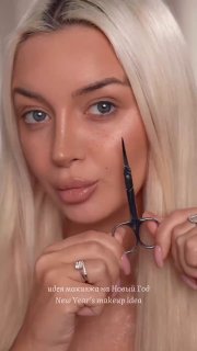 Блондинка держит ножницы у внешнего уголка глаза, показывая лайфхак с подручным предметом для коррекции стрелки.