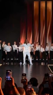 Сцена гала-концерта AGUTEENS FEST: Леонид Агутин и группа артистов на фоне тёплых декораций, зрители с телефонами