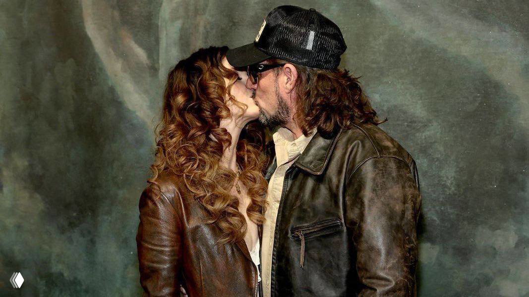 Лана Дель Рей целует своего мужа Джереми Дюфрена в портретном кадре с тёплой студийной палитрой после показа.