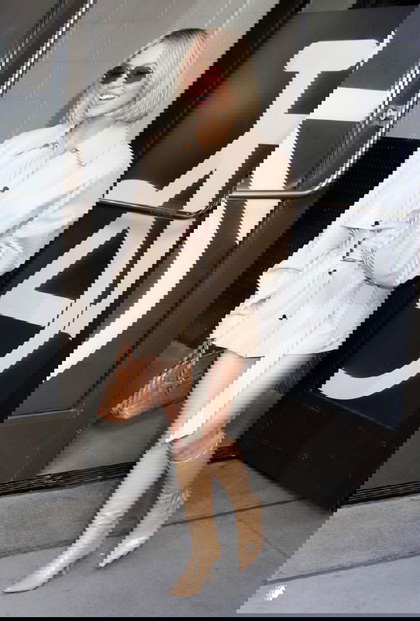 Дневной образ с бежевой короткой накидкой-пальто, кожаные бежевые сапоги по колено и маленькая сумочка — лёгкий городской сет.