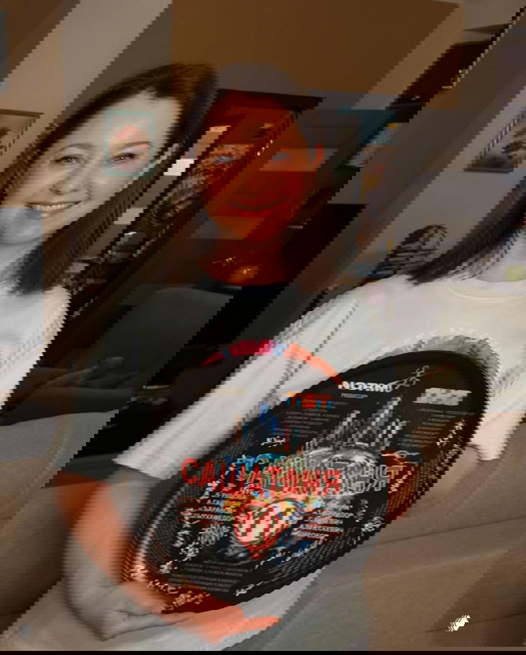 Портрет Валентины Рубцовой: актриса улыбается и держит диск с надписью «САШАТАНЯ 11», заметен интерьер съёмочной локации.