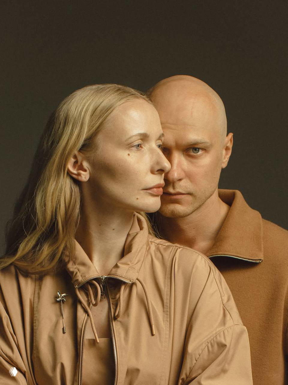 Крупный студийный портрет пары: мужчина и женщина обнимаются, художественная светотень и монохромный тон создают интимную атмосферу.