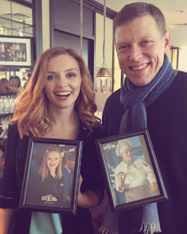 Актриса держит в руках framed-фото с логотипом «Отель Элеон»: тёплый закулисный снимок, где показывают память о ролях и съёмках 2016 года.