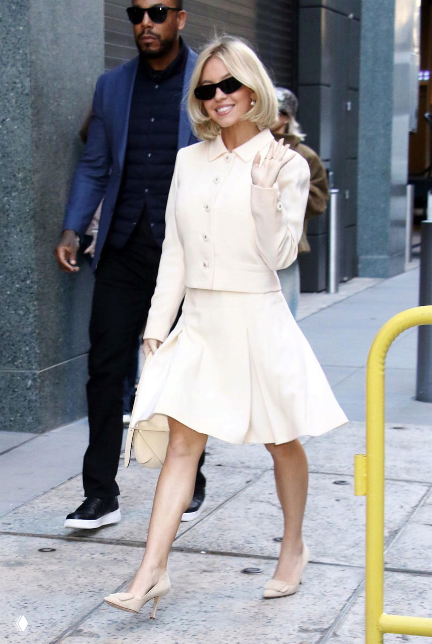 Кремовый костюм-юбка и жакет в светлой гамме, аккуратная причёска и лодочки — свежий дневной образ на прогулке по городу.