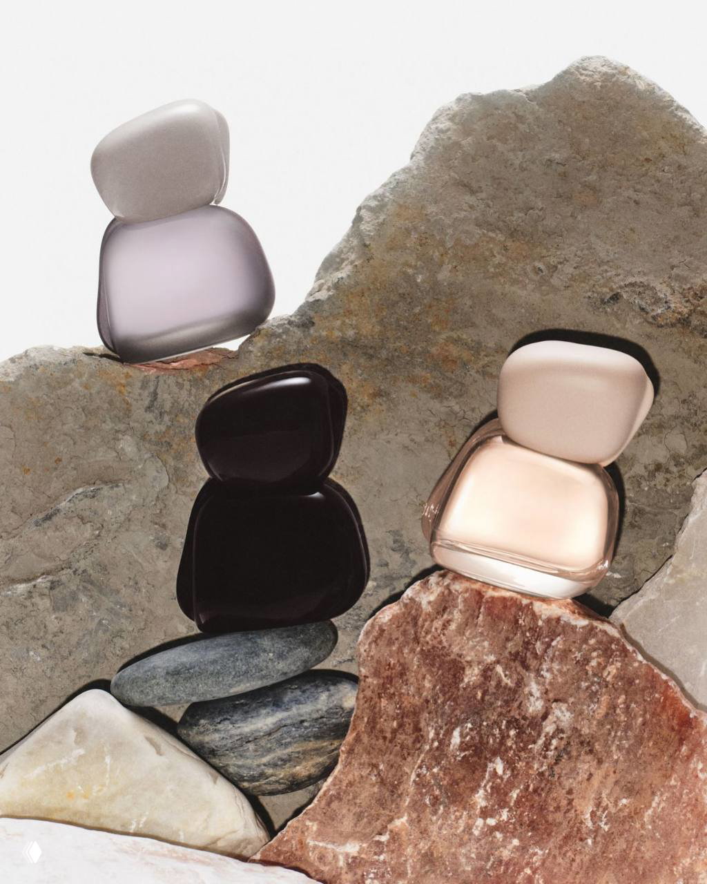 Флаконы парфюма Mood Stones, выложенные на каменных плитах; акцент на дизайне флаконов и натуральных фактурах фона рекламной съёмки.