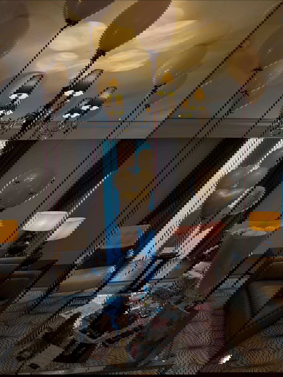 Интерьер номера или лаунжа украшен белыми воздушными шарами, букетами и подарками — подготовка к празднованию.