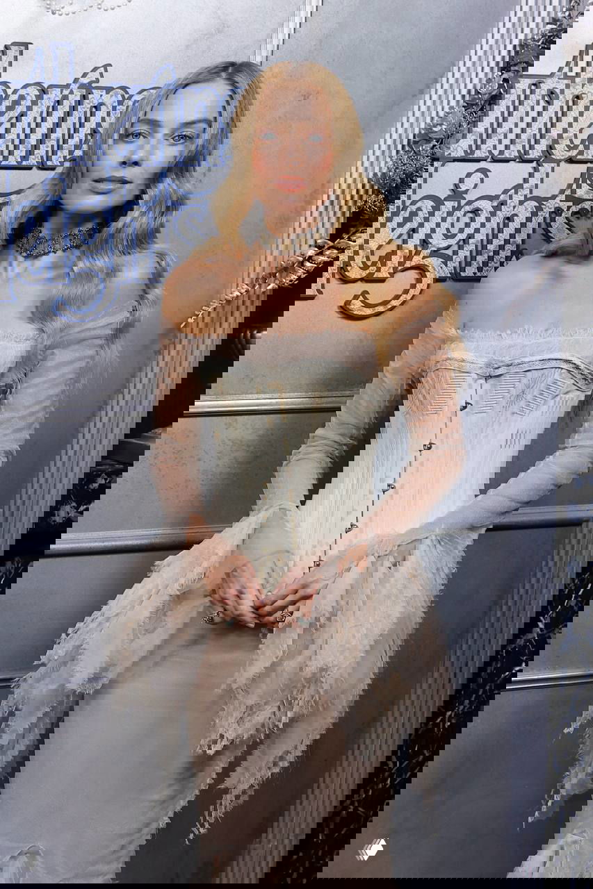 Портрет Марго Робби в романтичном образе с длинными волнистыми волосами и корсетным платьем на светской премьере.