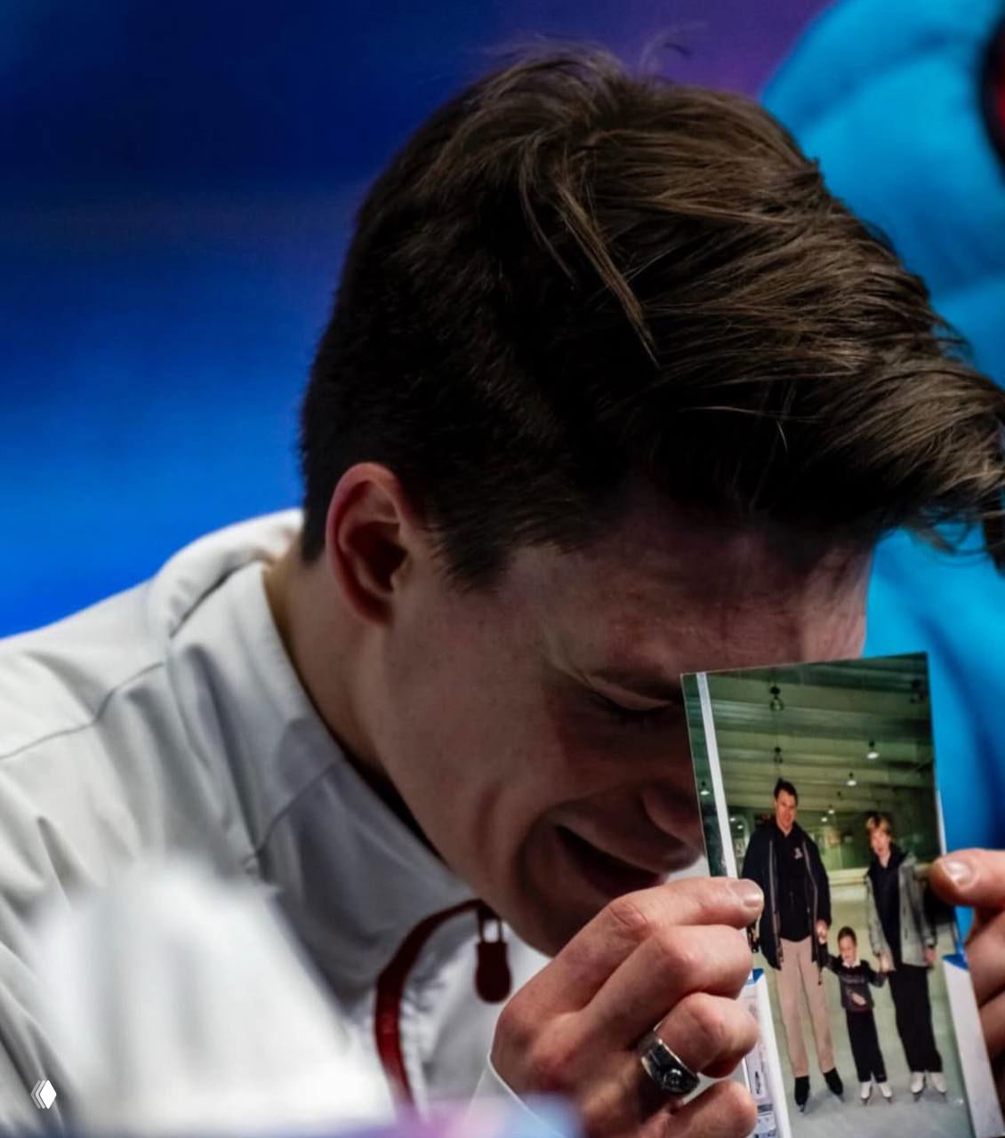 Эмоциональный кадр: Максим Наумов опускает голову и прижимает к лицу фотографию погибших родителей после проката на Олимпиаде.