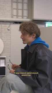 Персонаж в профиль: молодой человек с очками и капюшоном, неформальная сцена на съемочной площадке, естественное освещение