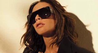 Виктория Бекхэм в крупном плане в солнцезащитных очках — кадр из рекламной съёмки для бренда Victoria Beckham, тёплое освещение.