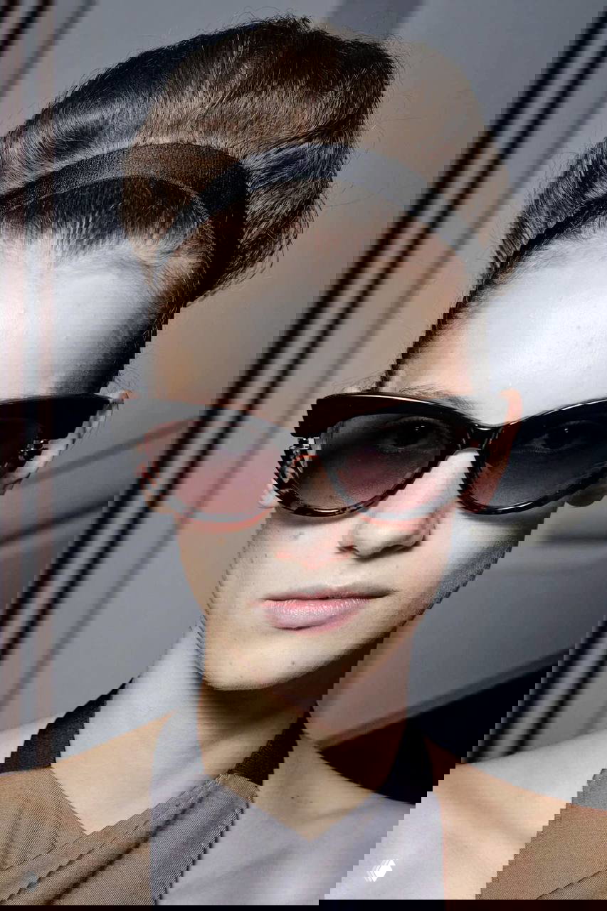 Портрет модели с высоким начесом и чёрной повязкой, ретро-укладка с объёмом у корней и крупными солнцезащитными очками как акцент сезона.