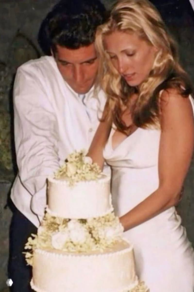 Пара в спортивно-повседневных образах идёт по тротуару, мужчина в шортах и кепке, женщина в джинсах и солнцезащитных очках, уличный снимок.