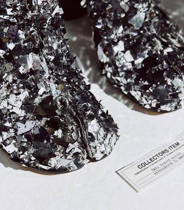 Крупный план покрытия обуви: пайетки, металлические детали и крупные осколки битого стекла, создающие фактурную сверкающую поверхность таби.