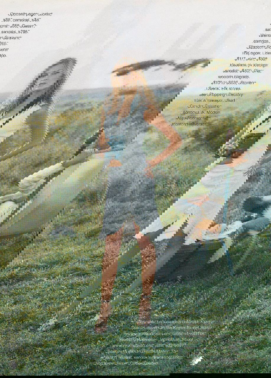 Модель на равнине с биноклем в белом комплекте: открытый пейзаж, травянистая степь и спокойная летняя атмосфера фотосета.