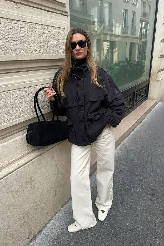 Чёрная ветровка с высоким воротником-стойкой в уличном кадре: оверсайз-силуэт, светлые джинсы и минималистичная сумка, уличный стритстайл.