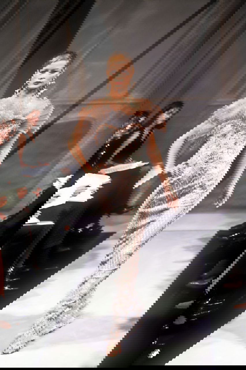 Модель в облегающем кружевном платье пастельных тонов с текстурными деталями и перьевыми акцентами; кутюрная работа Valentino.