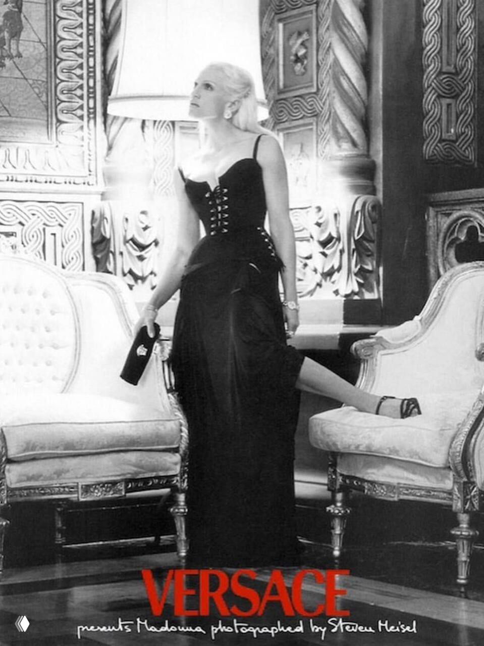 Мадонна в корсетном платье позирует в роскошном интерьере между креслами; чёрно‑белая студийная фотография из кампейна Versace.