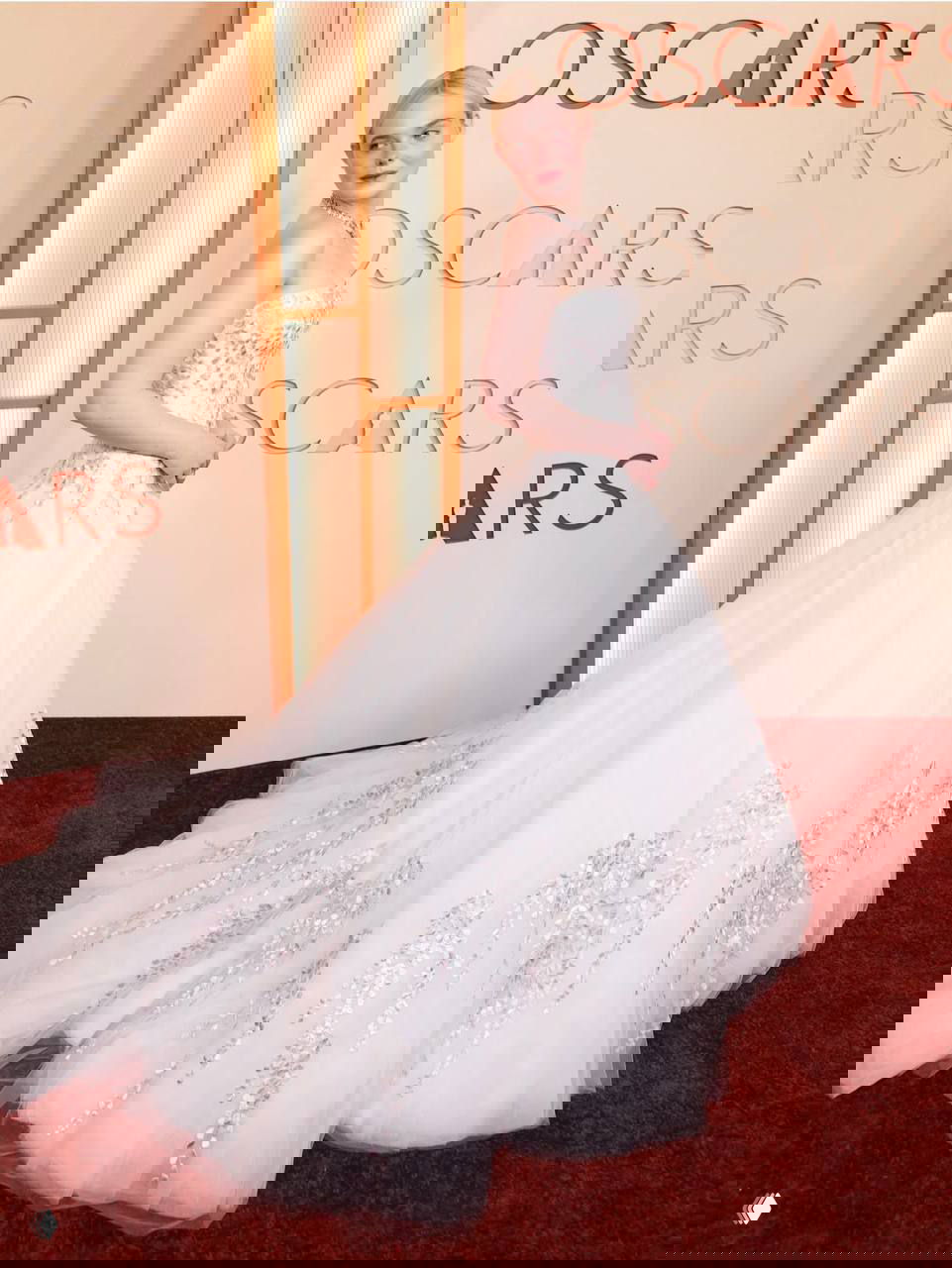 Молодая женщина в пышном белом платье-бальном силуэте на ковровой дорожке Оскара 2026, вид в полный рост с лёгким поворотом корпуса.