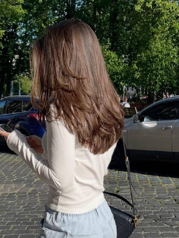 Вид сзади: длинные мягкие слои и естественный блеск волос, образ, демонстрирующий воздушность и лёгкость каскада.