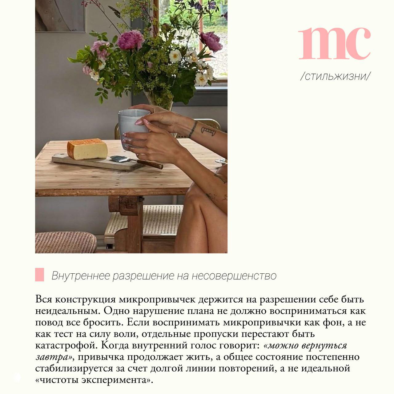 Руки держат кружку на деревянном столе рядом с ломтем хлеба и букетом цветов, символизирующее небольшие утренние или вечерние ритуалы и внутреннее разрешение на несовершенство.