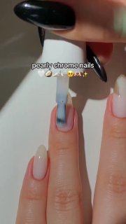 Кадр рабочего процесса: кисточка наносит перламутровую хромовую пудру на нюдовый ноготь, видна техника создания мягкого сияния.