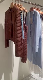 Вешалки с одеждой 12 STOREEZ в интерьере магазина: коричневый вязаный костюм и лёгкие изделия на деревянных плечиках, аккуратная визуализация ассортимента
