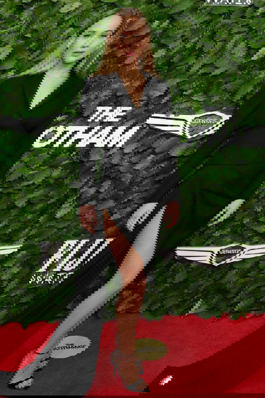 Дженнифер Лоуренс в черном элегантном наряде с высоким разрезом на красной дорожке Gotham TV Awards 2025 на фоне логотипов спонсоров.