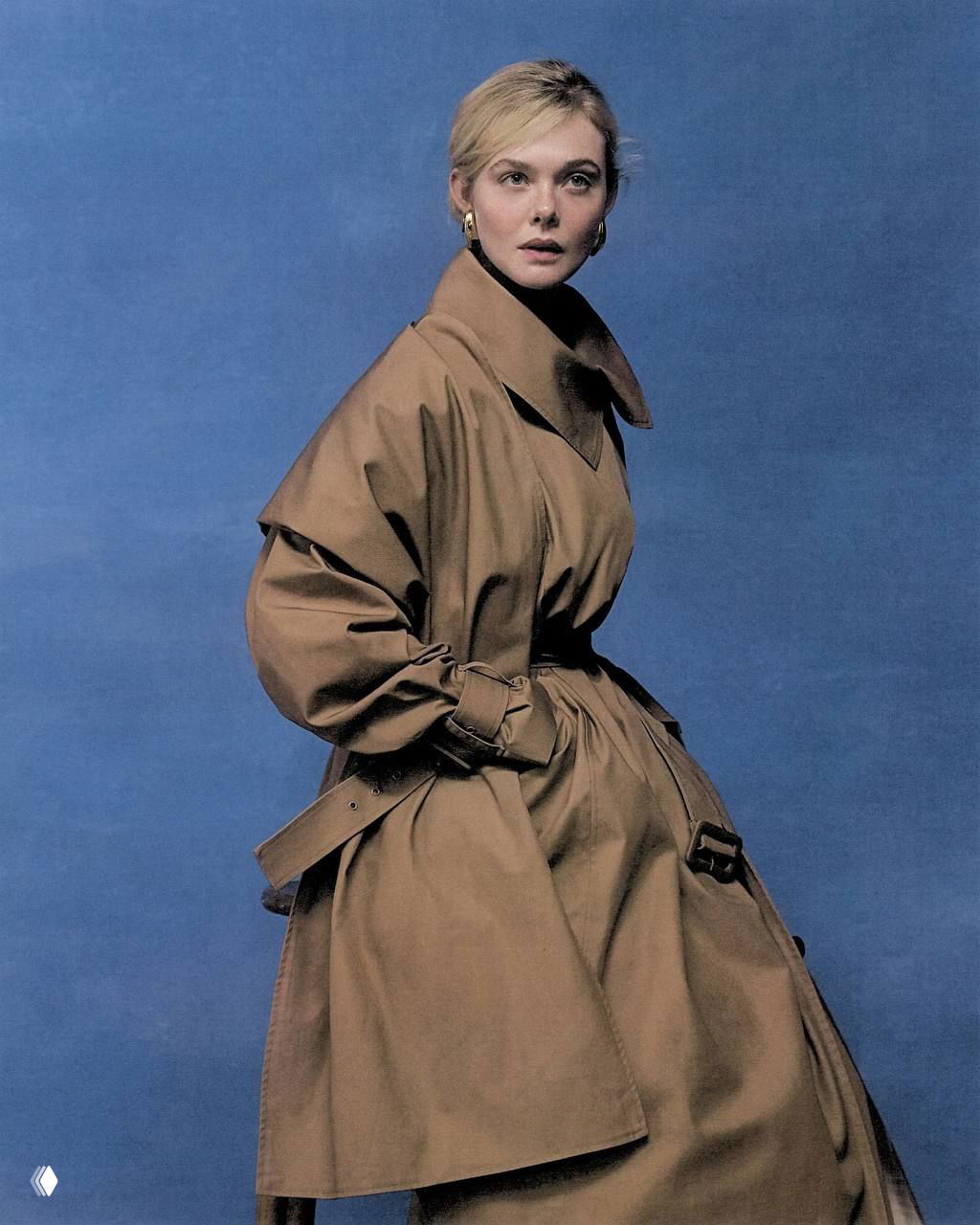 Портрет Эль Фаннинг в тренч-пальто на синем фоне — лаконичный модный портрет с элегантным силуэтом и деревянным полом.
