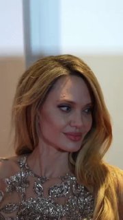 Крупный план Анджелины Джоли: детали вышивки у декольте платья, светлый макияж и прическа на премьере «Кутюр» в Париже.