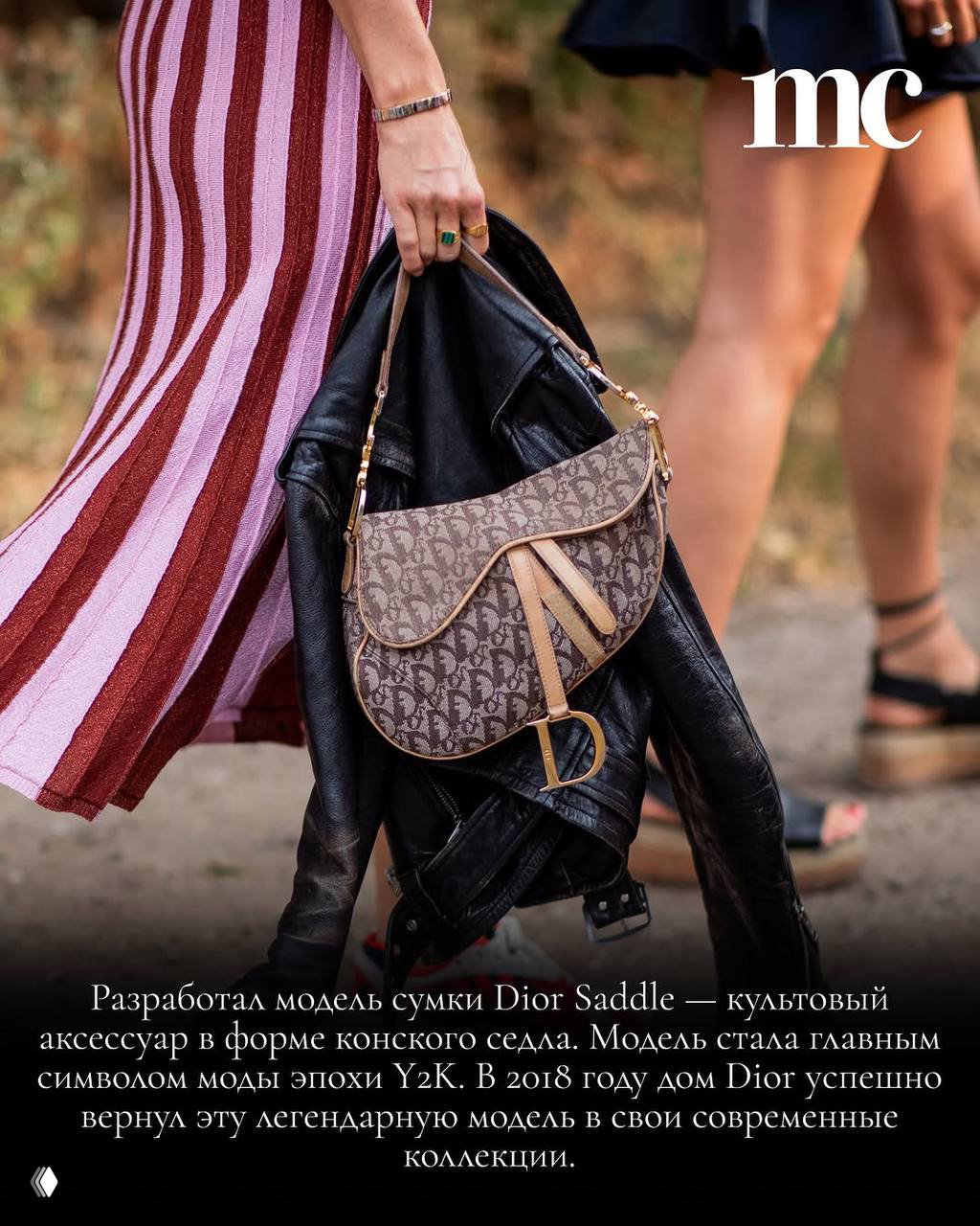 Рука держит сумку Dior Saddle на фоне плиссированной юбки и кожаной куртки — иллюстрация аксессуаров эпохи Y2K и наследия Гальяно.