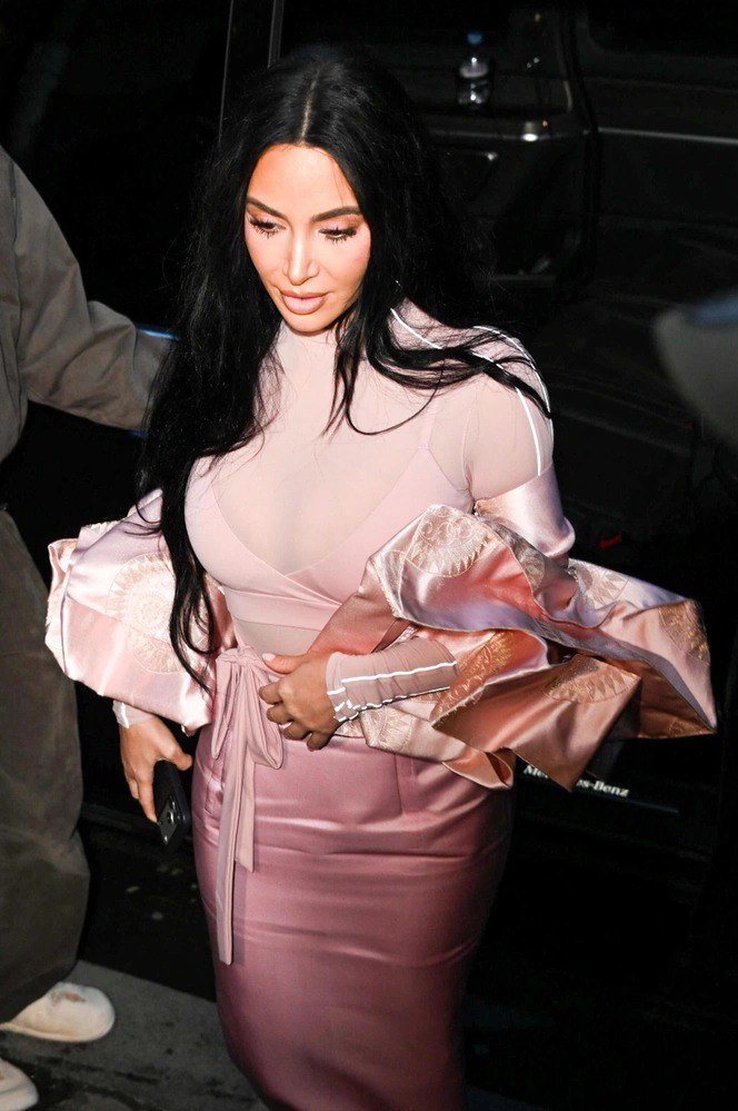 Крупный план модели в йогурто-розовом образе: полупрозрачный топ, бра в тон и пояс-узел на фоне тёмного автомобиля