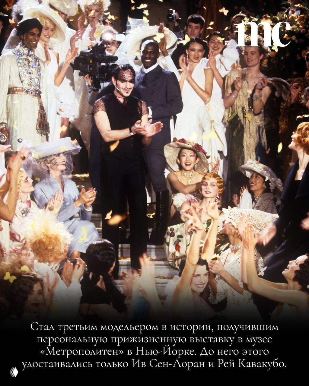 Финал показа с Джоном Гальяно на сцене и аплодирующей публикой; кадр передаёт энергетику и масштаб его исторических шоу-показов.
