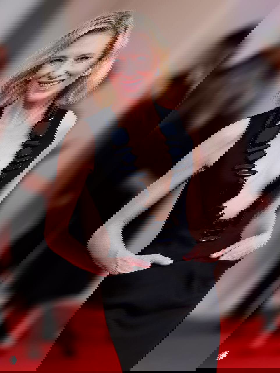 Кейт Бланшетт в похожем чёрном платье с глубоким вырезом и декоративными элементами, запечатлена на красной дорожке ранее в том же дизайне Armani.