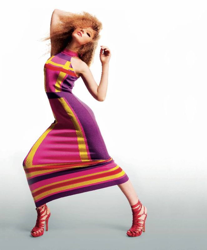 Модель в длинном фиолетово-розовом платье в динамичной позе на нейтральном фоне — редакционный fashion-кадр из Marie Claire, март 2009.