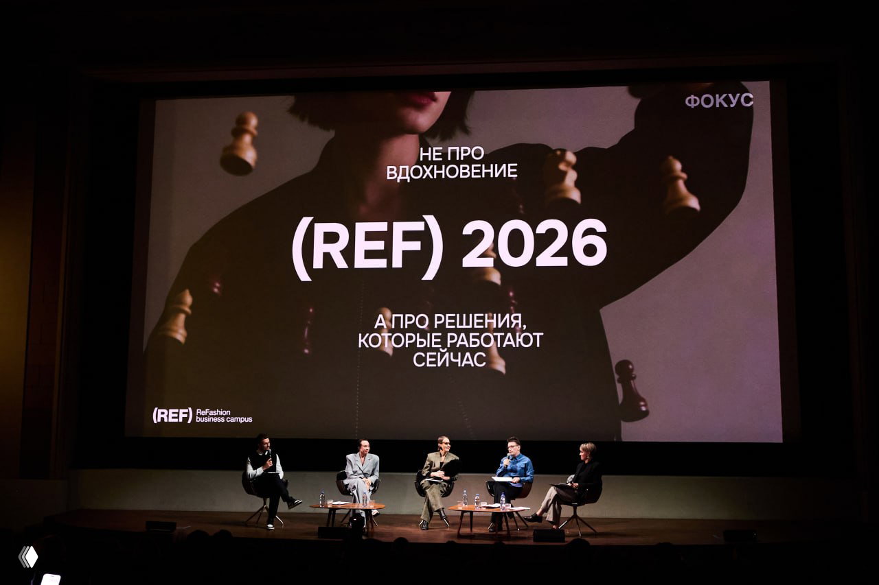 Широкий план сцены с большим слайдом «(REF) 2026»: перед экраном сидят модные эксперты и спикеры, ведётся обсуждение трендов и бизнес‑решений.